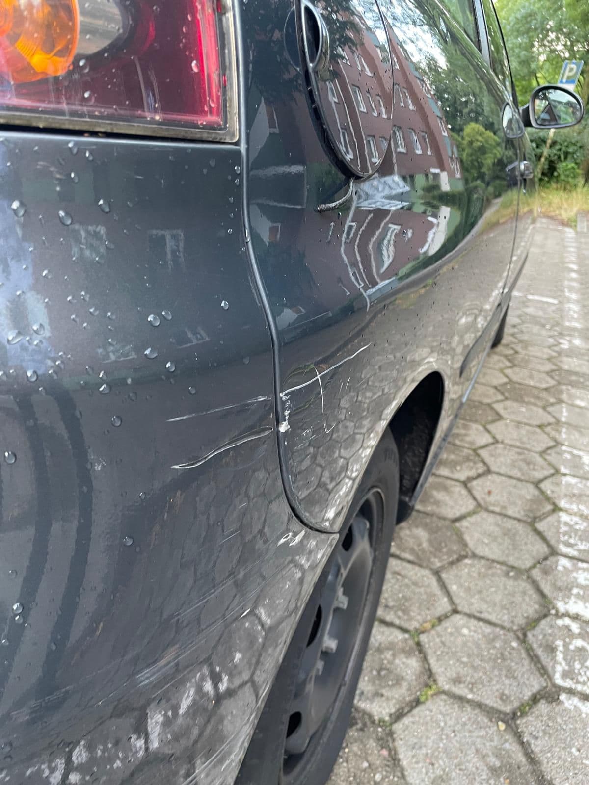 Streifschaden mit hellem Lackübertrag über Stoßfänger, Seitenwand und Radlauf
